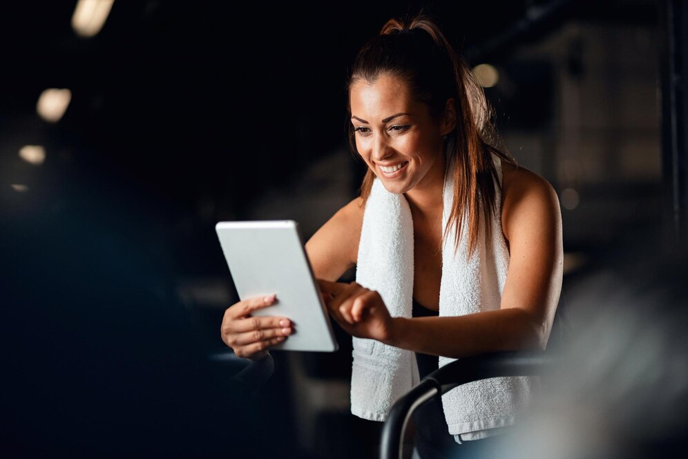 A woman after her training using fitness software on her tablet.
Source: Freepik